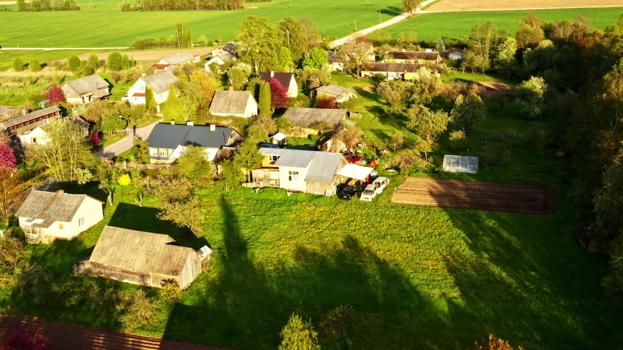 Aerial view of countryside village with homes, barns, trees and surrounding farmland