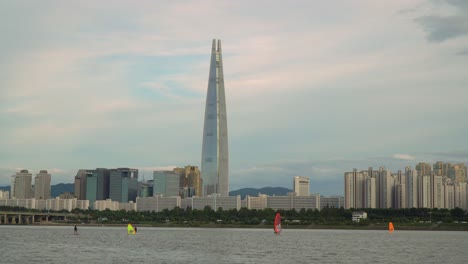 windsurfing on the han river in seoul, south korea with the lotte world tower in the background