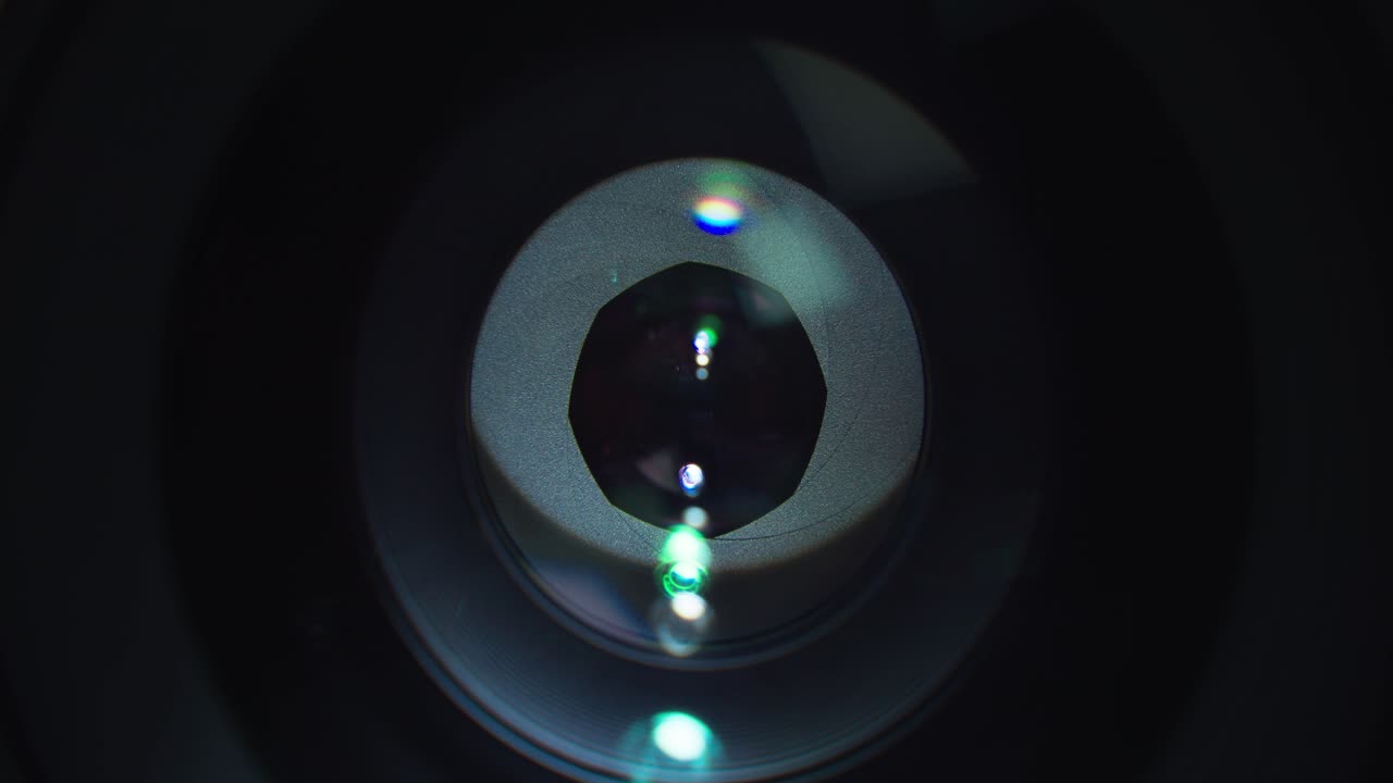 Opening and closing shutter on expensive lens with light reflection on it, close up view