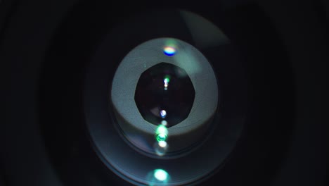 Opening and closing shutter on expensive lens with light reflection on it, close up view