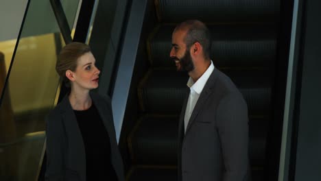 Business-people-interacting-on-an-escalator