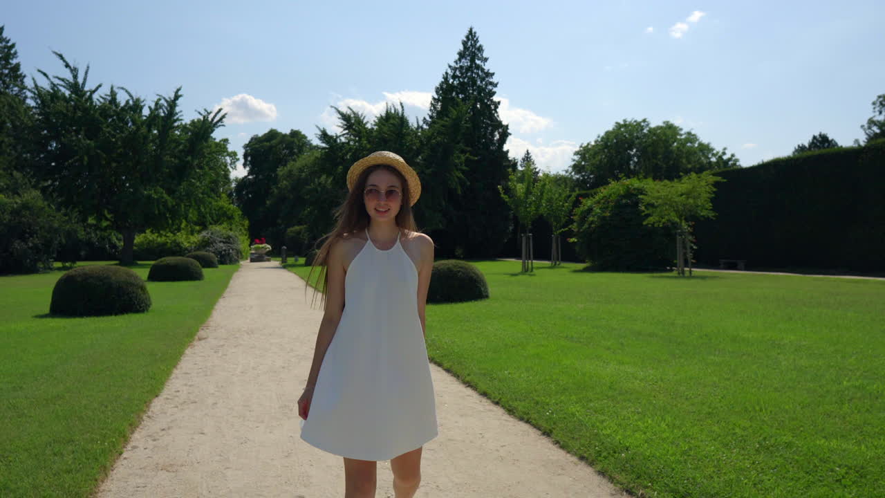 mujer con un vestido blanco caminando en un parque