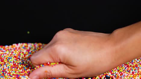 hands interacting with vibrant candy sprinkles