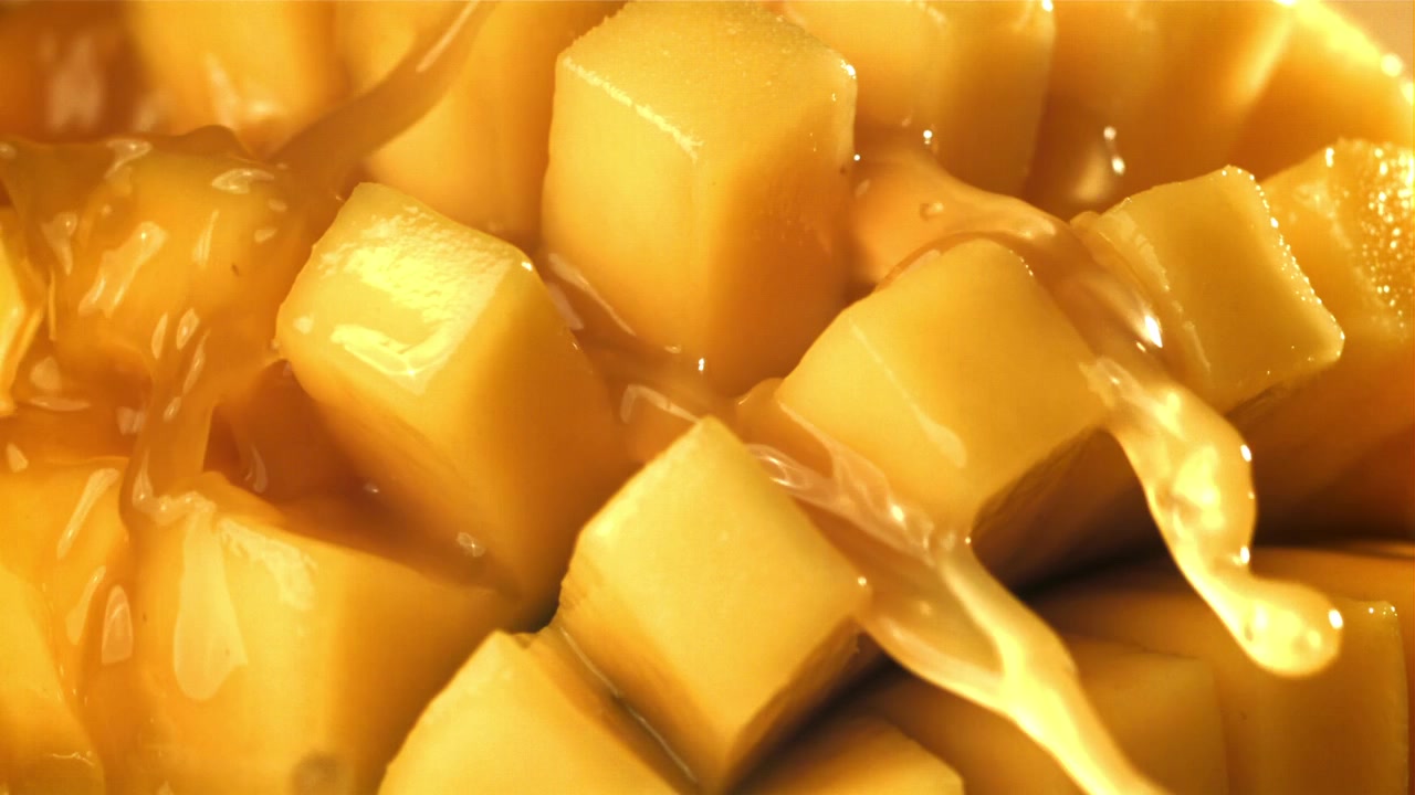 Close-up Sirup Emas Mengalir di Atas Potongan Mangga Segar