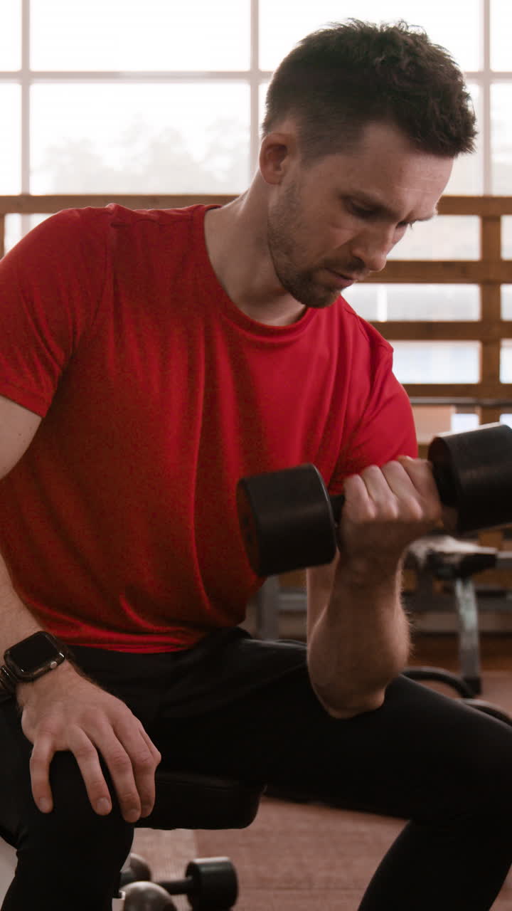 Man doing bicep curls with a dumbbell in a gym