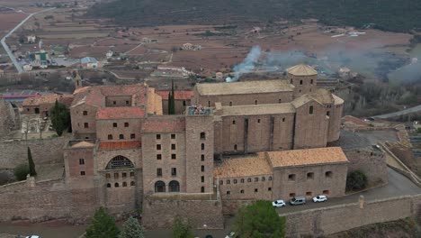 Historic-cardona-castle-surrounded-by-rolling-hills-and-picturesque-townscape,-aerial-view