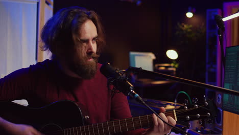 creative songwriter singing a song on microphone and playing his guitar