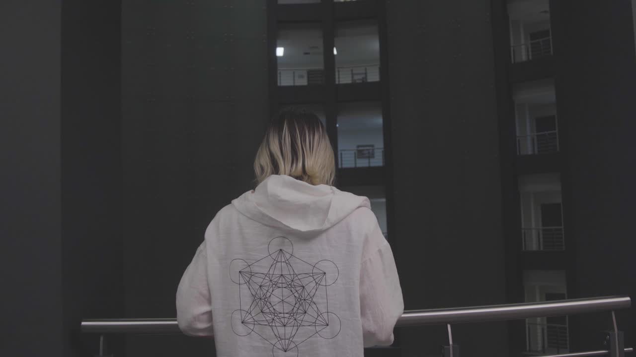 женщина смотрит на городский пейзаж с балкона