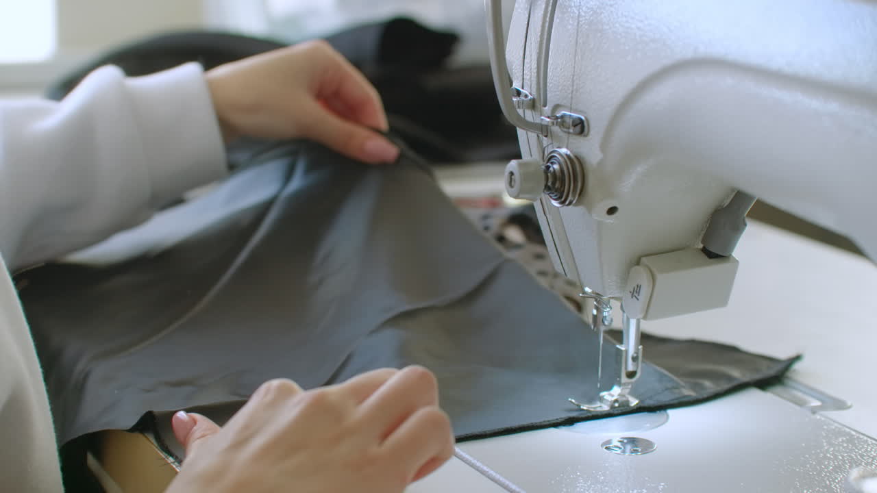 pequeño negocio y concepto de pasatiempo. joven mujer diseñadora de ropa trabajando en una máquina de coser en su estudio. en el interior