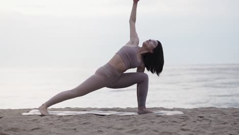 Mujer-Haciendo-Posturas-De-Yoga-En-La-Playa