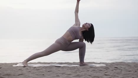 Frau-Macht-Yoga-Posen-Am-Strand