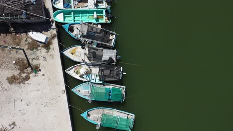 aerial view looking straight down and camera showing small wooden fishing boats in a harbor in mexico