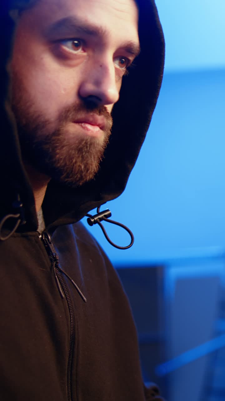 Lodret video. Nærbillede af hacker i graffitimalet skjulested, der er fokuseret på at udvikle spyware