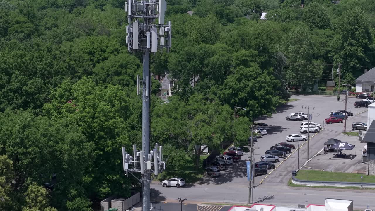 Aerial rising of Cell Tower or Base Station of telecom pole in neighborhood surrounded by trees