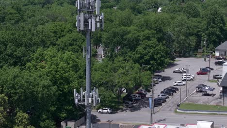 aerial rising of cell tower or base station of telecom pole in neighborhood surrounded by trees