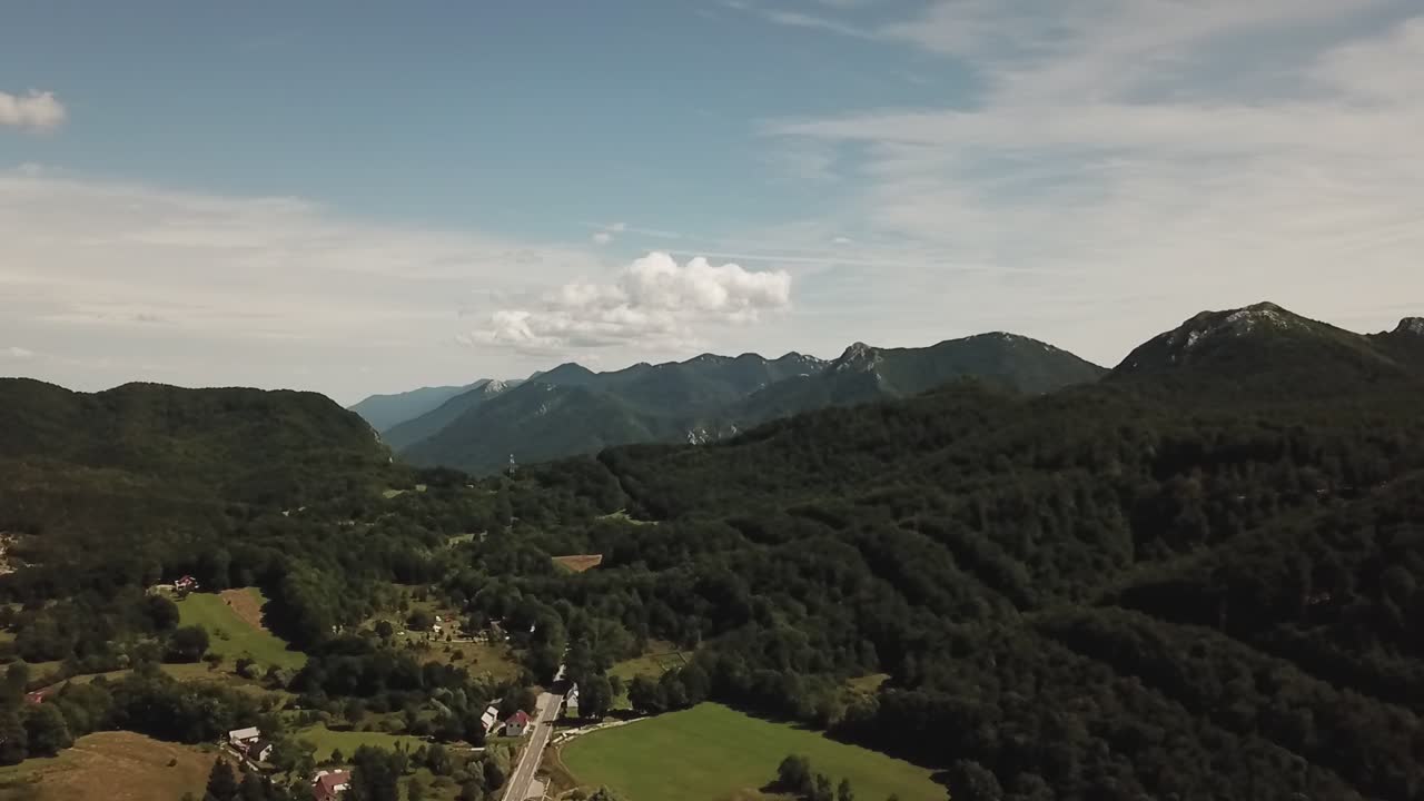 Riprese con drone che catturano il paesaggio montano accidentato della Croazia, caratterizzato da cime spettacolari, terreno roccioso e un vasto scenario naturale sotto cieli aperti
