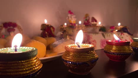 three beautiful diyas (oil lamps) burning in front of idols