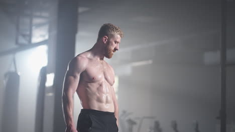 an athlete exhausted by training in the gym after performing the exercise rests and gains strength. a dense strong man recovers during a workout