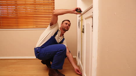 carpenter taking measurements of press