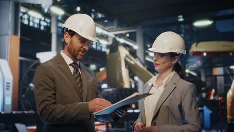el jefe de la fábrica haciendo un trato estrechando la mano con una ingeniera con casco de cerca.