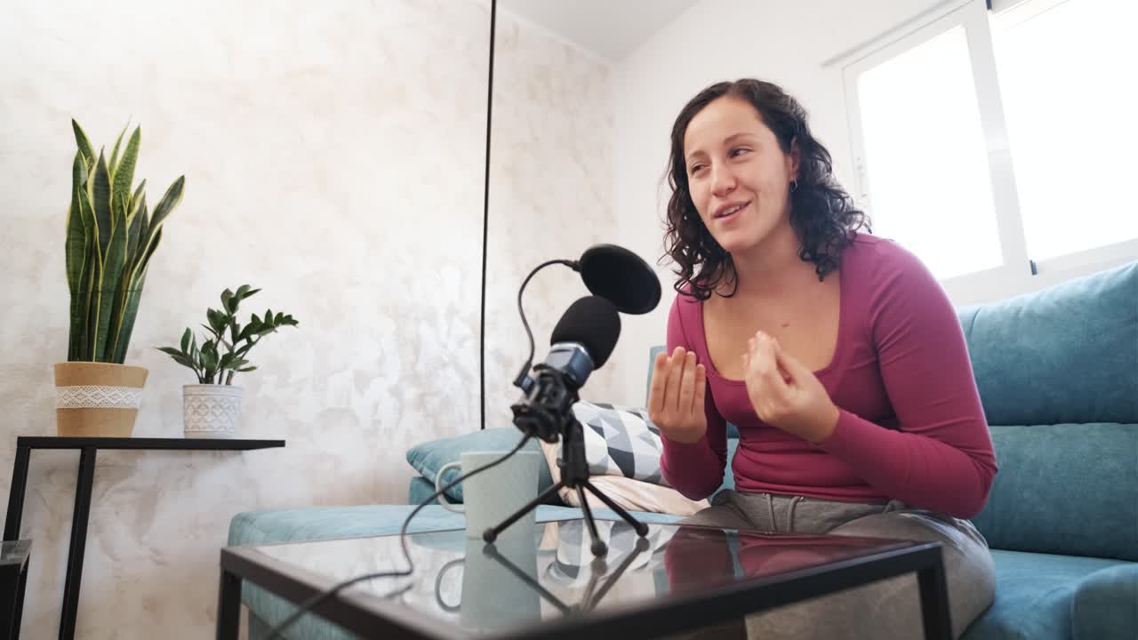 Caucasian woman recording a podcast in the living room at home