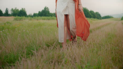 view of the legs of a woman walking on a country road