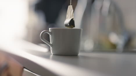 steeping tea bag in a warm mug on a kitchen counter