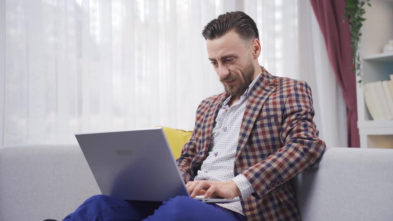 el hombre que usa la computadora portátil se alegra y es feliz.