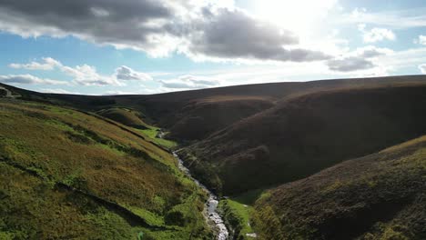 drone shot of river running through english countryside