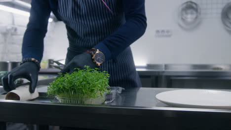 the cook puts sauces on table and starts to cut microgreens