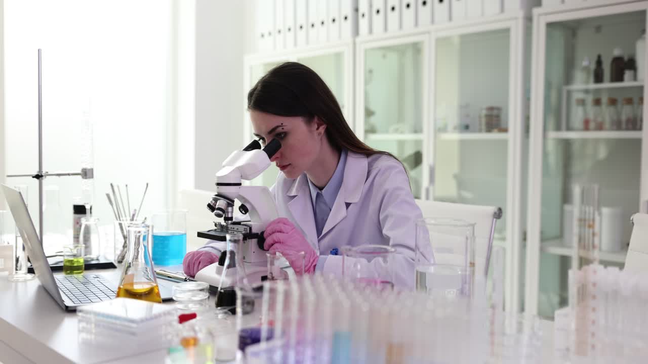Scienziata che lavora in laboratorio con il microscopio