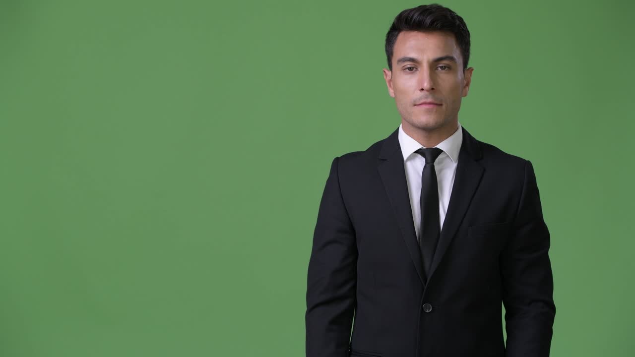 초록색 배경에 젊은 잘생긴 히스패닉 사업가