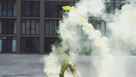 Fashionable-young-woman-on-urban-rooftop-using-a-smoke-grenade