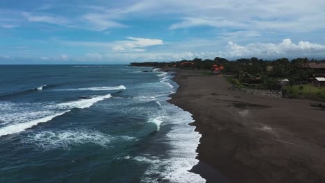 pererenan beach in bali indonesia showing dark volcanic sand, aerial dolly out reveal shot