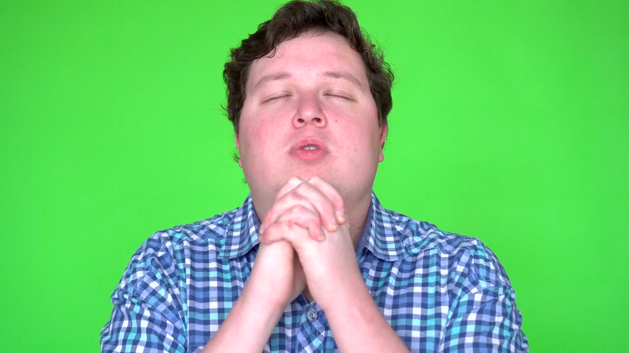 녹색 스크린 에서 기도 하는 젊은 남자