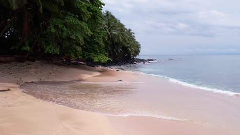 Olas-De-Paso-Elevado-De-Drones-Rodando-En-La-Playa-De-Arena,-Paisaje-Salvaje-De-La-Isla-Príncipe,-África