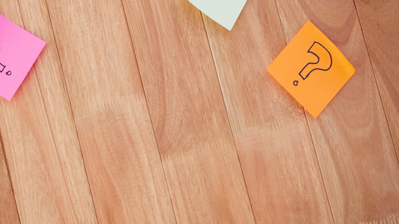 Question mark signs drawn on coloured memo notes stuck on wooden boards