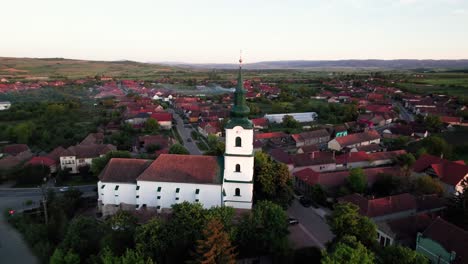 aerial orbit view of hungarian medieval protestant church in a green village