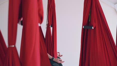 group sits in butterfly position in fly yoga hammocks