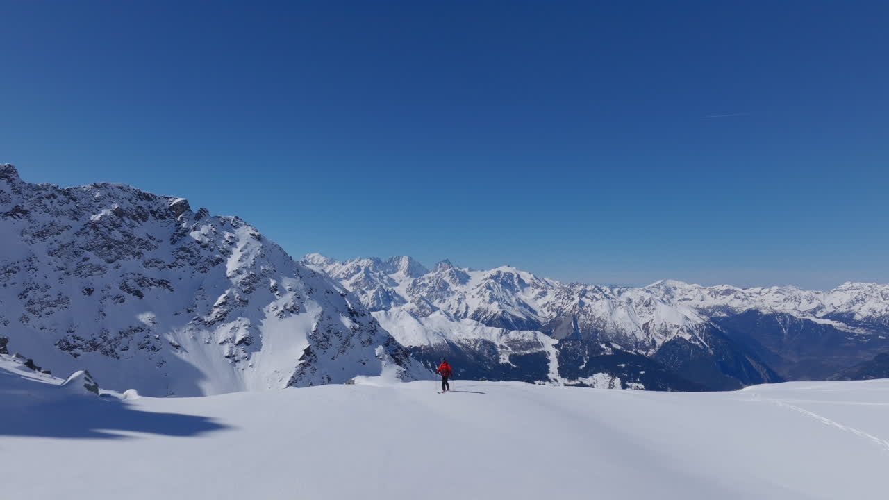 A professional skier hikes up a steep ridge in Verbier, then drops into an epic freeride descent. Pure adventure skiing in deep snow, dramatic terrain, and breathtaking alpine scenery.