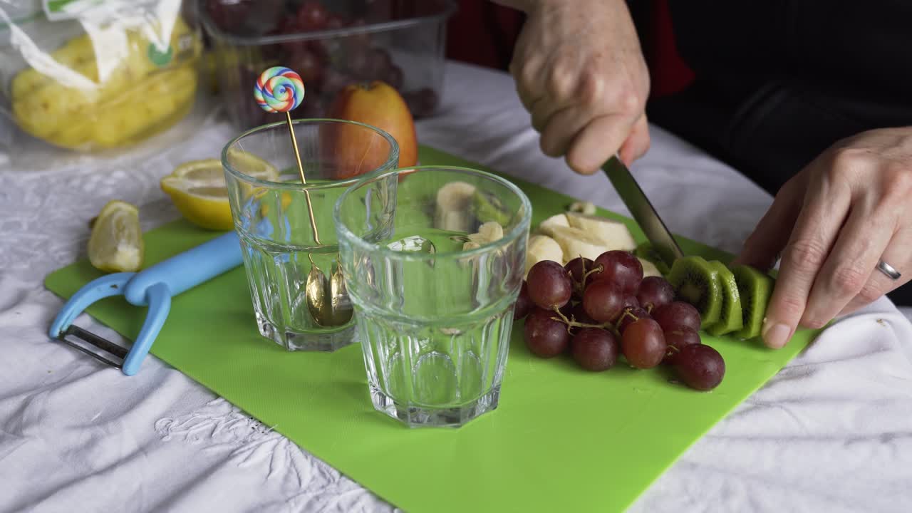 cortar kiwi con uvas y plátano para un desayuno afrutado fresco
