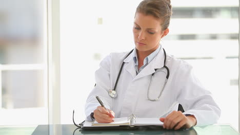 medical doctor writing notes in her journal