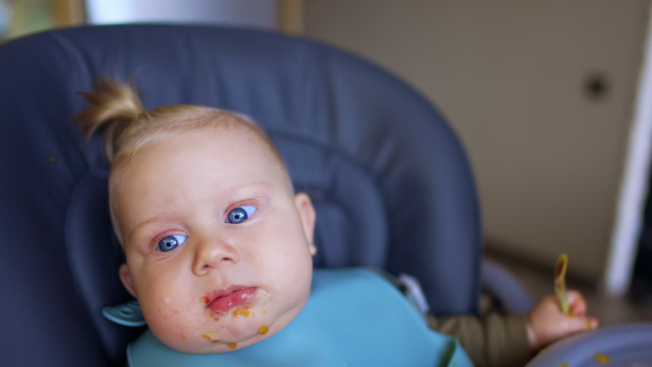 Lovely Caucasian baby face with some pieces of food around his mouth. Little kid after feeding. Close up.