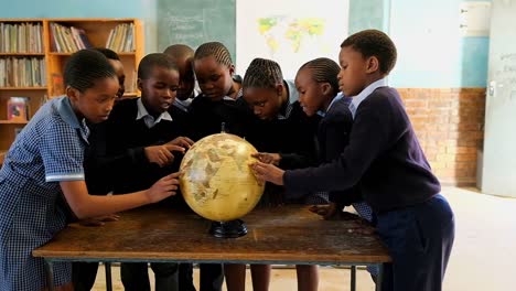 schoolkids using globe in classroom 4k