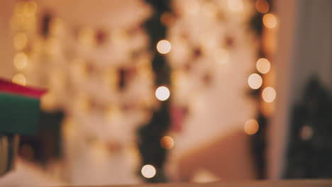 christmas theme. young woman puts the gifts under the christmas tree. in the defocusing.