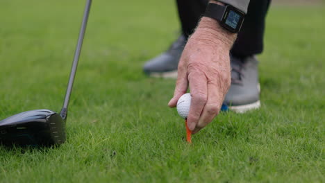 close-up of a golfer placing a golf ball on a tee