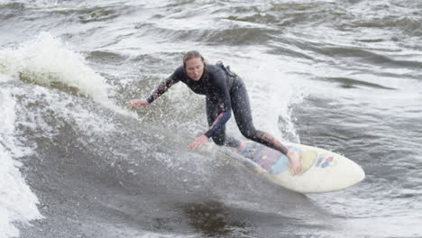 woman athlete - surfing on a river wave