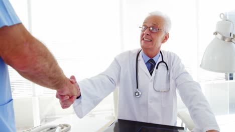 Male-doctor-shaking-hands-with-coworker