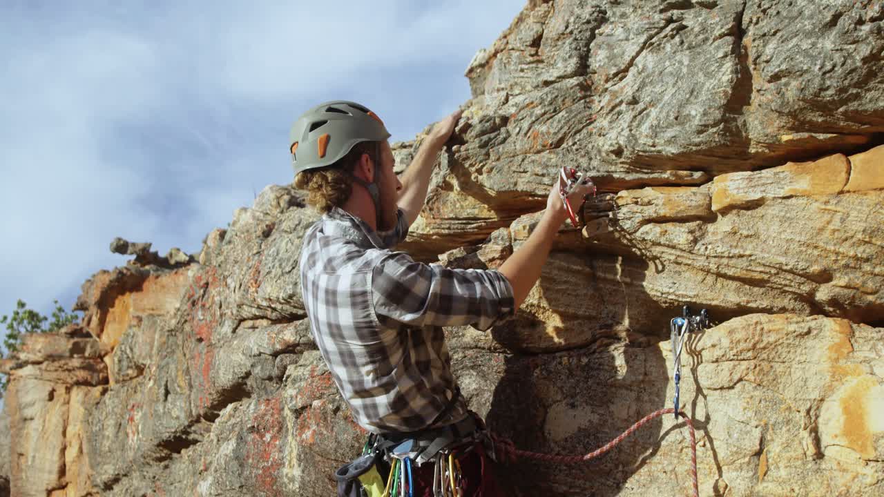 montañero tratando de ajustar el equipo de escalada 4k