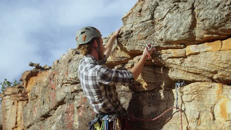 mounatineer trying to adjust the climbing equipment 4k